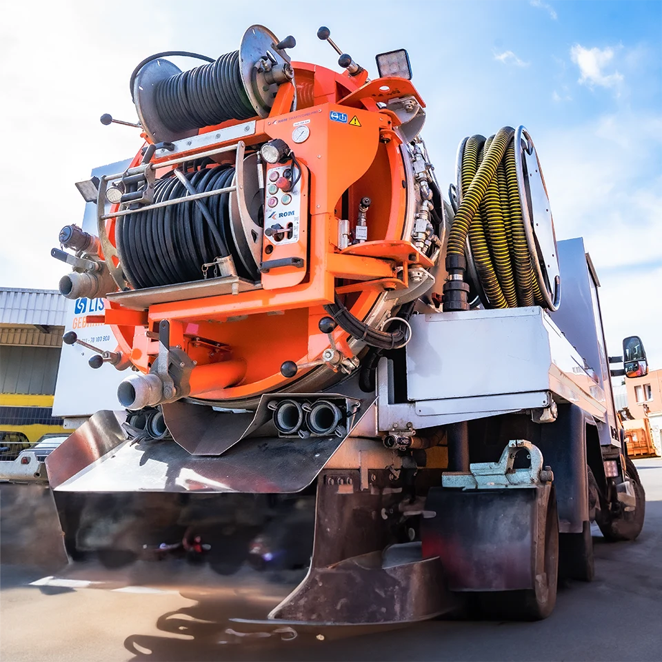 Leistungsstarkes Saugfahrzeug mit moderner Technik zur professionellen Rohr- und Kanalreinigung, ausgerüstet mit Hochdruckschläuchen und robustem Edelstahlaufbau.