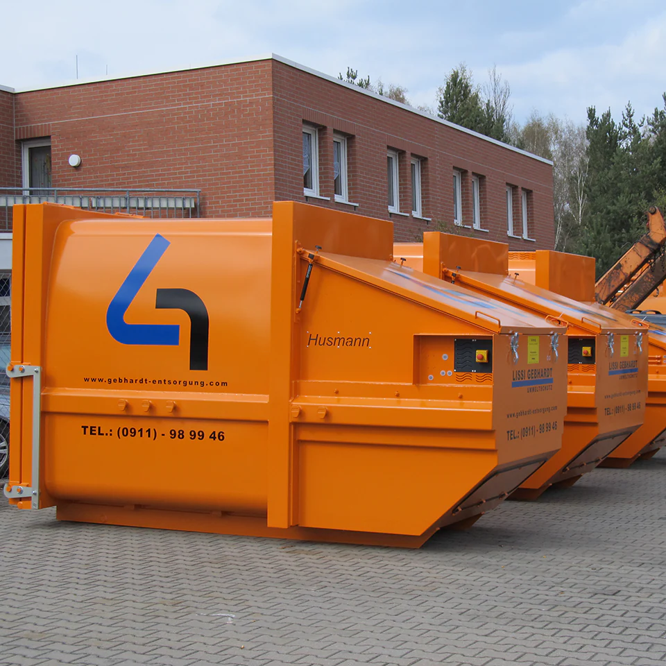 Mehrere orangefarbene Abfallcontainer von LISSI GEBHARDT auf einem Betriebsgelände. Symbol für moderne Containerlösungen in verschiedenen Größen und Ausführungen – ideal für Bauprojekte, Gewerbeabfälle und Sondermüllentsorgung.