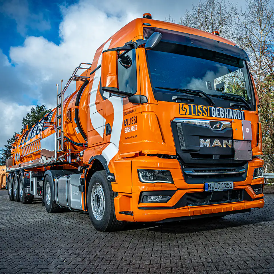 Moderner orangefarbener Entsorgungs-Lkw von LISSI GEBHARDT auf einem Firmengelände. Symbol für den leistungsstarken Fuhrpark des Familienunternehmens – seit über 70 Jahren Garant für sichere, schnelle und gesetzeskonforme Entsorgung.